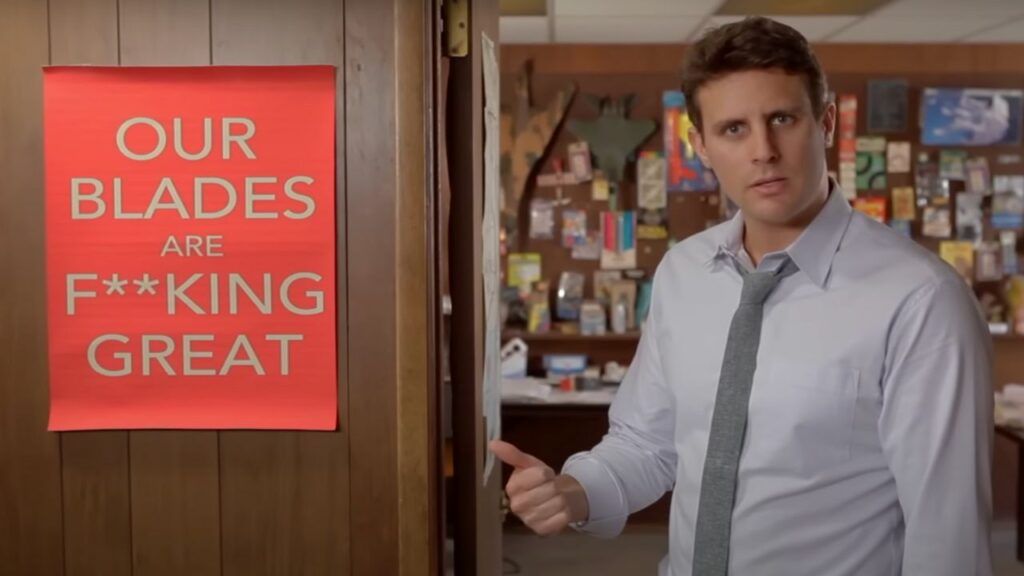 Una scena del video di Dollar Shave Club, in cui il CEO indica un cartello rosso con su scritto